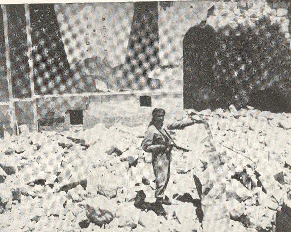 Иорданский солдат держит свток Торы на руинах Синагоги. 1948